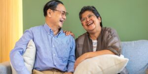 An elderly Asian couple laughing together